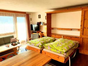 马洛亚Pra d'Sura 104的一间卧室配有一张床、一张沙发和一张桌子