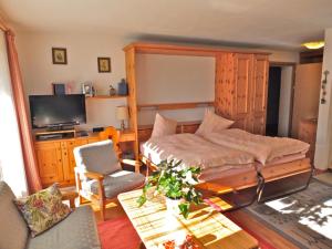 马洛亚Pra d'Sura 104的一间卧室配有一张床、一张桌子和一台电视。
