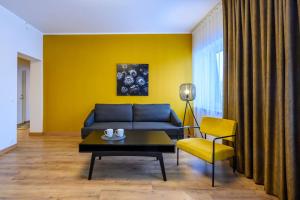 塔尔图Kastani Factory Apartments的客厅设有蓝色的沙发和黄色的墙壁