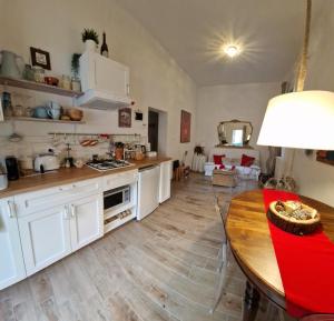 博洛尼亚Minimal Chic House的厨房配有白色橱柜和木桌
