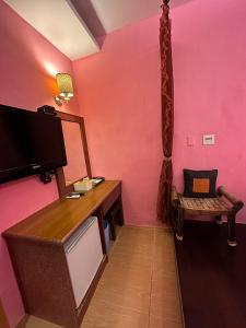 垦丁大街垦丁海晴天旅店的配有粉红色墙壁、桌子和椅子的客房