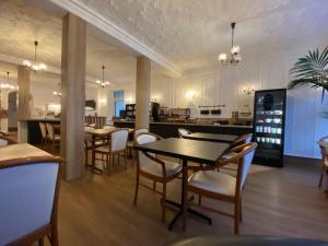 瑟堡卢浮宫酒店的一间带桌椅的用餐室和一间厨房