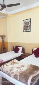 拉明德The Lumbini Village Lodge的一间设有两张床的客房,墙上挂着一张照片