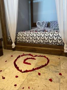 阿维尼翁L'EXCELLENCE AVIGNON - Suite LUXE SAUNA, HAMMAM & JACCUZZI的地板上用红色花做的心床