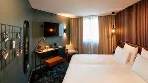 巴黎Le Bellune Paris的配有一张床和一张书桌的酒店客房