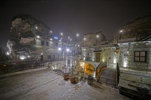 格雷梅Risus Cave Suites的一座晚上下雪的建筑