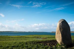 KillalaIsland Winds Along The Atlantic Way的水体旁的一块地里的岩石