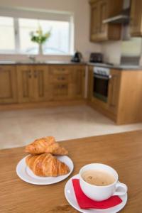 KillalaIsland Winds Along The Atlantic Way的厨房里的桌子上放着咖啡和羊角面包