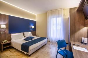 斯波托尔诺米迪泰拉尼酒店的酒店客房,设有床铺和蓝色的墙壁
