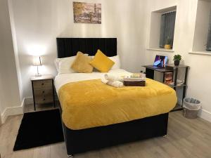 伯恩利Luxurious New 2 Bed Apartment in Burnley, Lancashire的一间卧室配有一张黄色毯子床