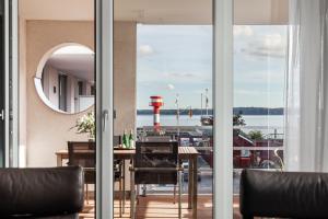 埃肯弗德Apartmenthaus Hafenspitze Ap 5 - "am Yachthafen 5" - Blickrichtung offenes MeerStrandpromenade - a72320的一间设有桌子并享有海港景色的用餐室
