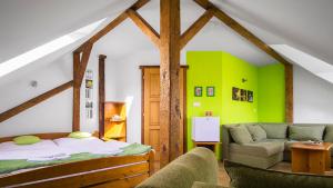 Unčínpenzion Horácko的一间卧室设有绿色的墙壁、一张床和一张沙发