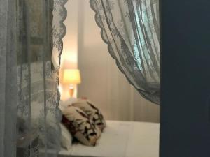 斯基罗斯岛Katoi House - Central Skyros Village的一间卧室配有一张带窗帘和灯的床