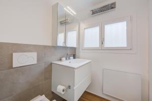 PianderaCasa Elvezia - Happy Rentals的白色的浴室设有水槽和镜子
