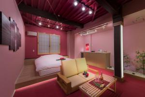 八王子市ホテル 鳳凰 大人専用的卧室设有粉红色的墙壁、一张床和一张桌子