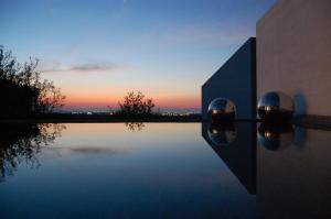奥斯图尼卡尔赛比安卡住宿加早餐旅馆的水池,背景是日落