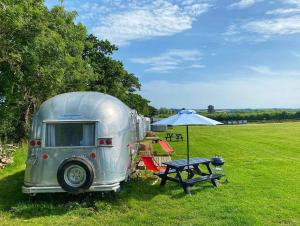 赖德Retro Staycations的银色拖车,带野餐桌和雨伞
