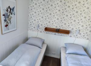 亨讷斯特兰德BLÅBJERGGAARD - Hennebysvej 60的配有壁纸的小客房内的两张床