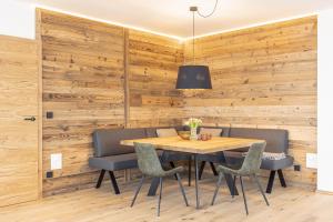 滕嫩山麓圣马丁Hideaway Dachstein West by ALPS RESORTS的用餐室设有木墙和木桌及椅子
