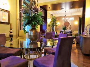 CerdeiraQuinta da Palmeira - Country House Retreat & Spa的一间带桌子和紫色椅子的用餐室