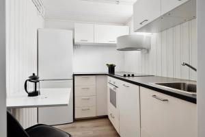 特隆赫姆Adorable 1-bedroom apartment with a fantastic view - Free Parking的白色的厨房配有白色橱柜和水槽