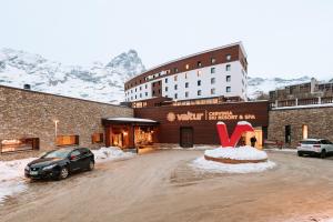 布勒伊-切尔维尼亚Valtur Cervinia Cristallo Ski Resort的把车停在雪地覆盖的停车场的酒店