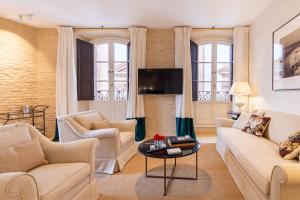 塞维利亚Real Casa de la Moneda Deluxe Apartments的客厅配有沙发和桌子