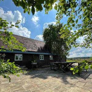 普尔伯勒House on the Brooks Self catering Holiday let South Downs West Sussex Sleeps 14的大楼前的野餐桌和长凳