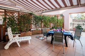 格罗塞托港罗萨海神公寓式酒店的庭院配有桌椅和植物