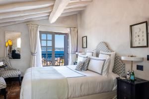 圣特罗佩Le Yaca Saint-Tropez的一间卧室设有一张床,享有海景