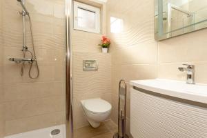 巴斯卡Santima Apartments的带淋浴、卫生间和盥洗盆的浴室