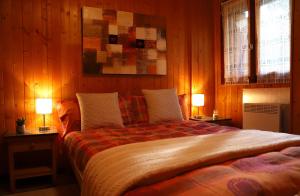 Mesocco[Chalet Villa Maria] con Vista Montagne - Netflix的一间卧室配有一张大床和两盏灯