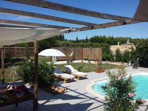 AramonL'EN HAUT的一个带游泳池、遮阳伞和桌子的庭院