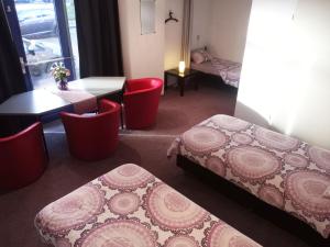 鹿特丹泽文坎普住宿加早餐酒店的一间设有两张床和一张桌子及椅子的房间