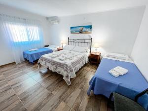 罗尔丹Nuevo Hotel Parador的配有蓝色床单的客房内的两张床
