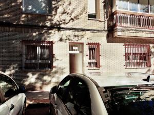马德里Acogedora Habitación en Madrid的停在砖楼前的白色汽车
