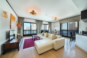 迪拜Park Apartments Dubai, an Edge By Rotana Hotel的客厅配有白色沙发和落地窗