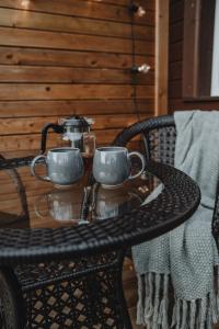 AugšlīgatneAlejas apartamenti的桌子上放着两个杯子,茶壶