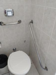 阿莱格雷特Hotel Caverá的浴室设有白色卫生间和残疾人栏杆。