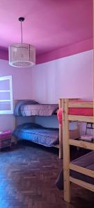 萨尔塔Hostel LQueen 1的客房设有两张双层床和紫色天花板。