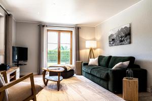 上施陶芬Himmelseck的客厅配有绿色沙发和电视