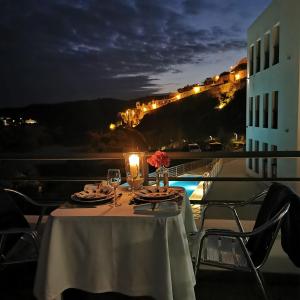 莫托拉博物馆酒店的夜晚在阳台上摆放着酒杯和鲜花的桌子