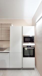米兰Fiera Milano City Apartment的厨房配有白色橱柜和微波炉