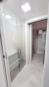米兰Fiera Milano City Apartment的一间带步入式淋浴间和玻璃门的浴室