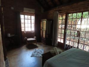 玛洛斯帕克Bush and Gables House的一间卧室配有一张床、一把椅子和窗户。
