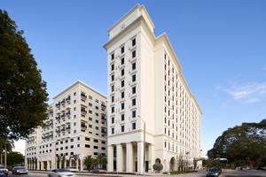 迈阿密THesis Hotel Miami的两座高大的白色建筑,坐在街道旁