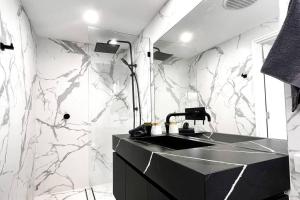 珀斯Studio C by Breckler Park的浴室设有黑色水槽和大理石墙壁。