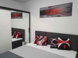 ZiemitzModerne Ferienwohnung mit Balkon direkt an der Peene的一间卧室配有红色和黑色枕头的床
