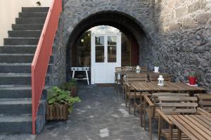 蓬塔德尔加达Azorean Urban Lodge的一间设有木桌和石墙的餐厅