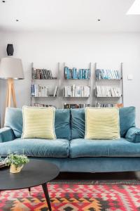 温彻斯特The Oaks, Twyford Moors, South Downs National Park的客厅里设有一张蓝色的沙发,配有书架